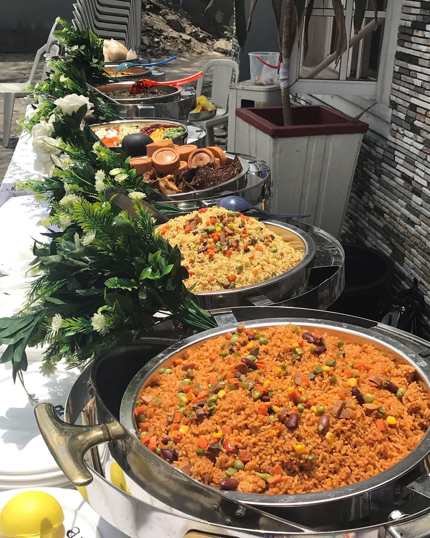 Jollof rice in a round serving dish on a buffet decorated with greenery