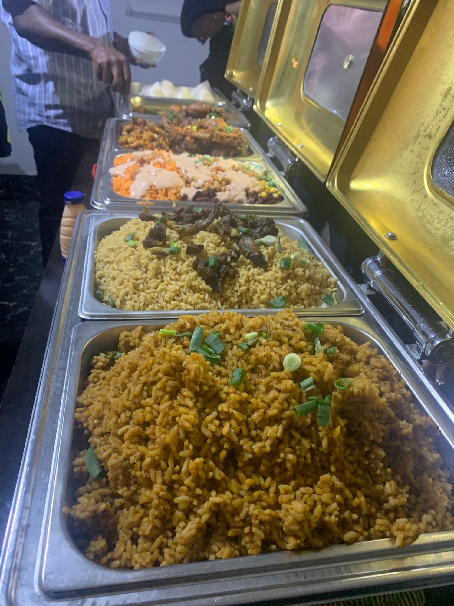 Trays of rice, fish and chicken on a buffet line
